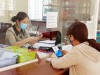 Cán bộ của Bộ phận tiếp nhận và trả kết quả BHXH huyện Lộc Ninh hướng dẫn người dân cài VssID. Ảnh: Nguyệt Cát